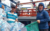 Ngư dân mang rác về bờ khi tàu cập cảng cá Quy Nhơn. Ảnh: Ái Trinh